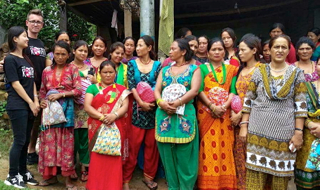 (L-R) A Nepalese %22We All Rotate%22 volunteer, Binita, with Steve and women from a rural village clasping their newly gifted sanitary kits